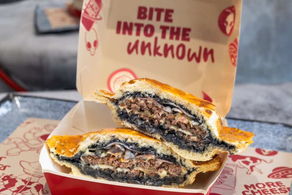 Egy különleges, fekete színű burger felvágva egy dobozban.