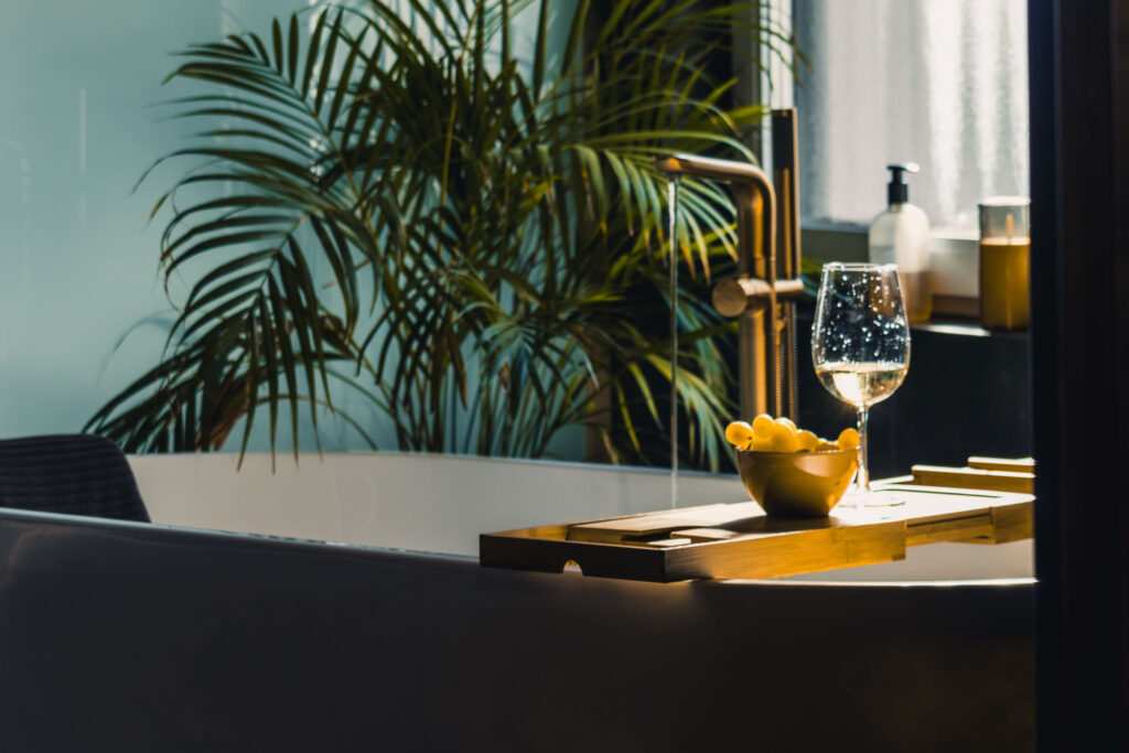 Luxus fürs Badezimmer: Badewanne mit Wein und Pflanze.